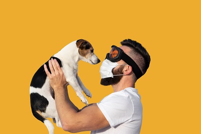 マスクをして犬を抱く男性