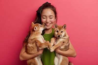 犬と猫を抱いた女性